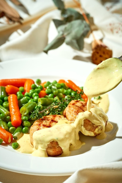 Almôndegas de frango com legumes cozidos no vapor em um prato Toalha de mesa branca leve e resistente