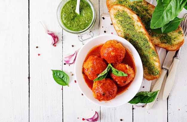 Almôndegas em molho de tomate e torradas com pesto de manjericão. Jantar. Comida saborosa. Vista do topo. Configuração plana