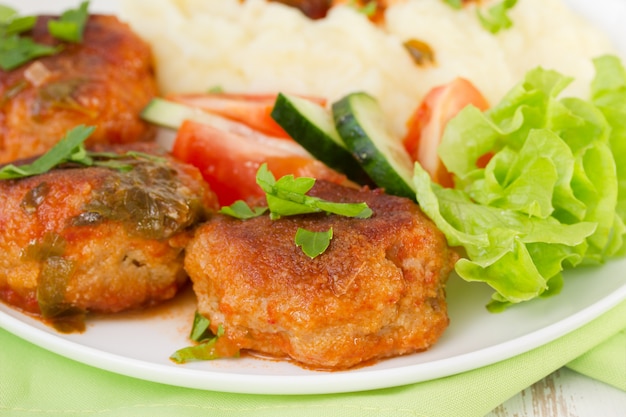 Almôndegas fritas com purê de batata, molho e salada