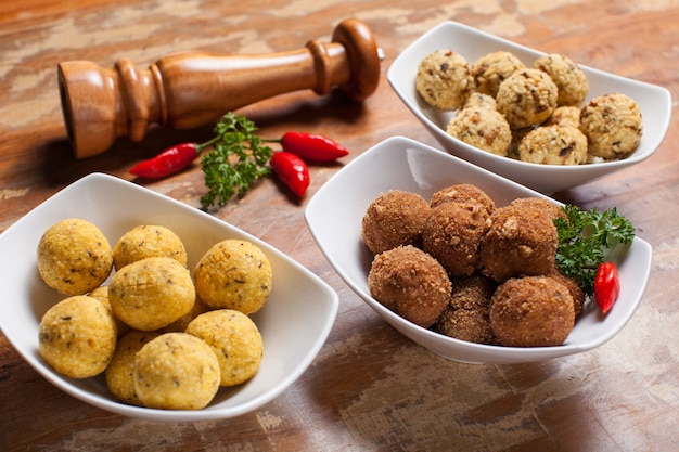 Almôndegas fritas, pimenta malagueta e moedor de pimenta na mesa de madeira