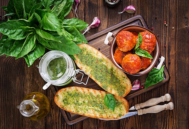 Almôndegas no molho de tomate e brinde com pesto da manjericão. Jantar. Comida saborosa. Vista do topo. Lay plana