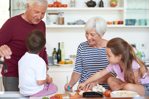 Almuerzo con los abuelos Foto de abuelos preparando la cena con sus nietos en la cocina