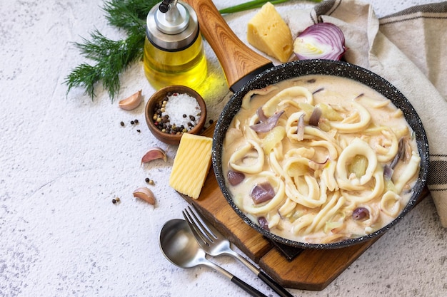 Almuerzo dietético Keto Anillos de calamar en salsa de queso crema agria sobre una mesa de piedra gris Espacio de copia