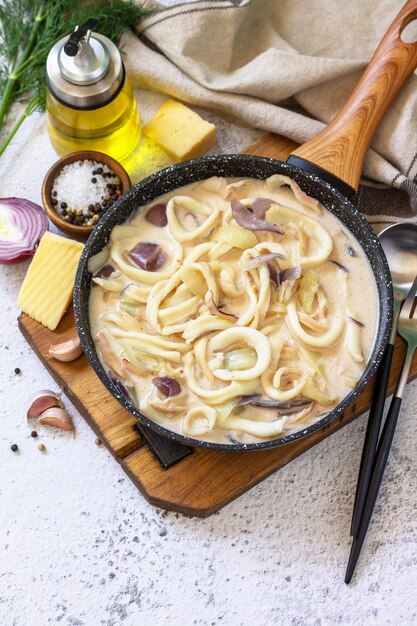 Almuerzo dietético Keto Anillos de calamar en salsa de queso crema agria sobre una mesa de piedra gris Espacio de copia