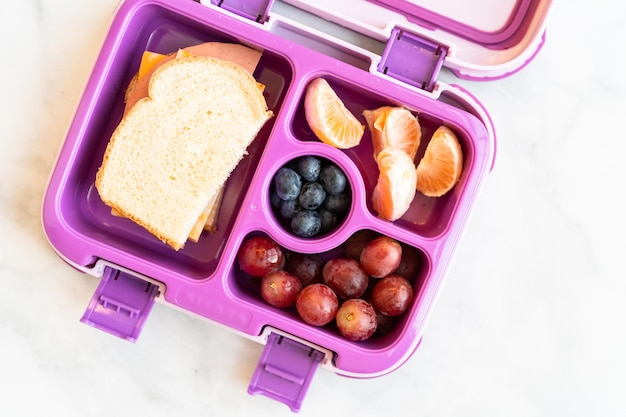 Almuerzo escolar saludable empacado en una caja bento para una niña.