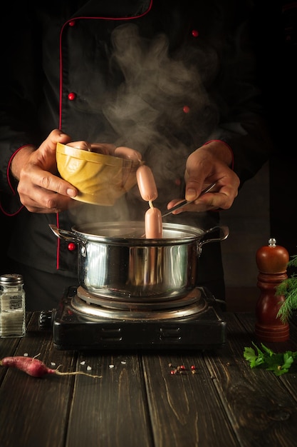 Para el almuerzo hay que cocinar deliciosas salchichas de carne Chef en la cocina en el trabajo