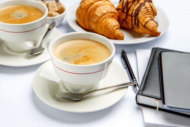 Foto almuerzo de negocios: cruasanes recién hechos y café