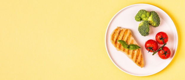 Almuerzo con pollo, brócoli y tomates.