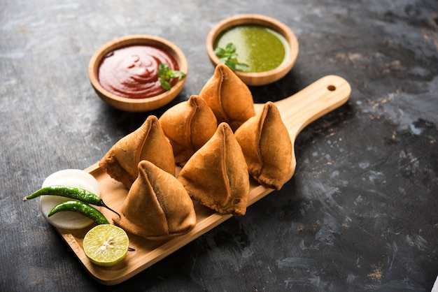 Almuerzo de samosa servido con ketchup de tomate y chutney de menta