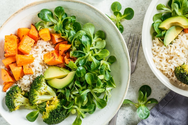 Almuerzo vegano con arroz, brócoli, camote, arroz y ensalada, vista superior. Concepto de comida vegana.