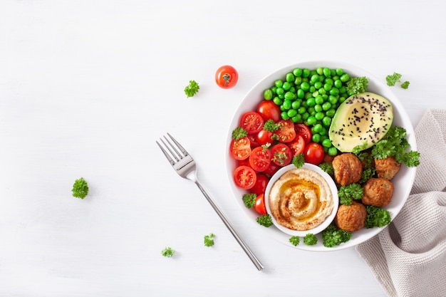 Almuerzo vegano saludable con falafel hummus tomate aguacate guisantes