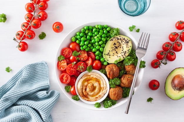 Almuerzo vegano saludable con falafel hummus tomate aguacate guisantes