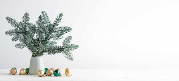 Almuerzos de árboles de Navidad en un jarrón con bolas sobre una mesa blanca