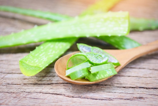 Aloe Vera-Betriebsscheibe auf rustikalem Holzabschluß oben des frischen Aloe Vera-Blattes mit natürlichen Kräutern des Gels und Kräutermedizin