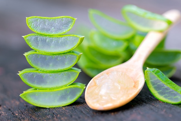 Foto aloe vera en cuchara de madera en mesa de madera hay muchas hierbas útiles.