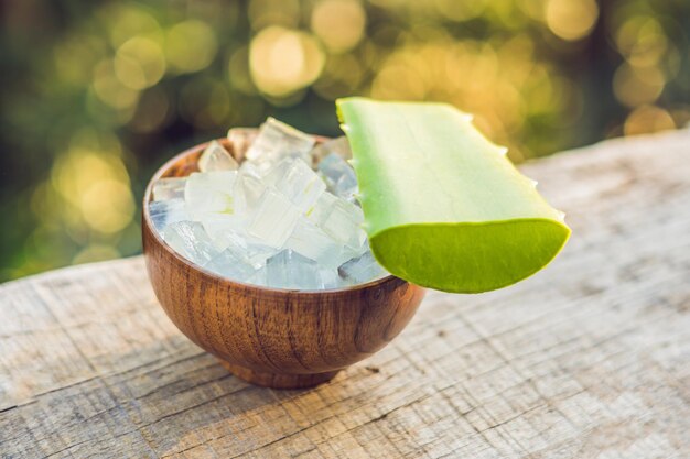 Aloe vera e cubos de aloe em uma tigela de madeira. Gel de Aloe Vera quase usado na indústria de alimentos, remédios e beleza