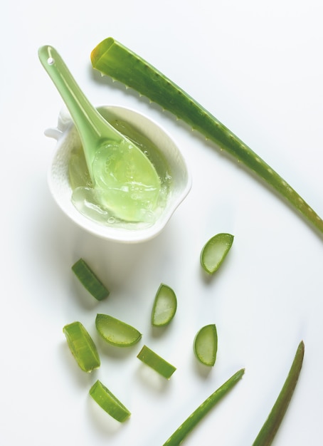 Aloe vera fatiado e em uma tigela branca com colher verde.