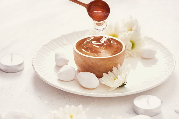 Aloe Vera Gel auf einer Schüssel, mit Chrysantheme und Kerze in Steintisch