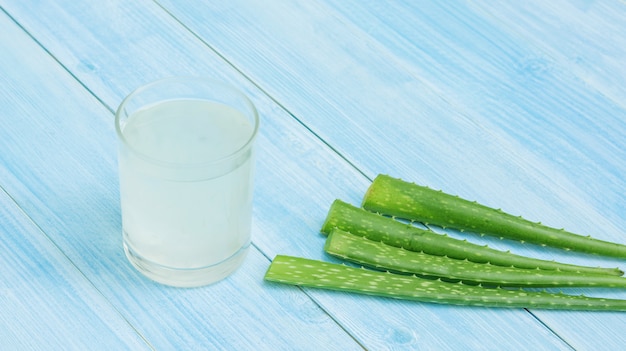 Aloe Vera Saft auf einem blauen Holztisch.