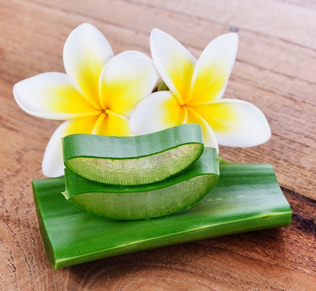 Aloe Vera und Frangipaniblume auf hölzernem