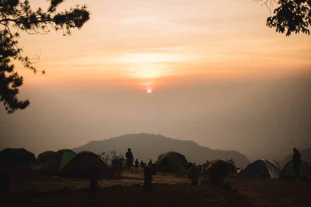 Alojamiento en carpa naranja de turistas para ver la niebla de la montaña negra con brumoso amanecer ver fro