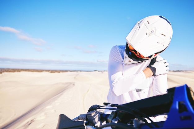 Foto alongamento de dor no ombro e pessoa em moto com distensão ou lesão no deserto pronta para esportes radicais treinamento de desempenho e piloto machucado na natureza para exercício com moto em estrada de terra