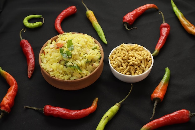 Aloo, Kanda Poha con sev rodeado de chile rojo y verde, famoso plato de desayuno Indori sev poha