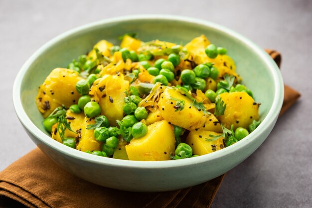 Aloo Mutter o Matar aalu dry sabzi, patata india y guisantes fritos junto con especias y adornados con hojas de cilantro. servido con roti o chapati