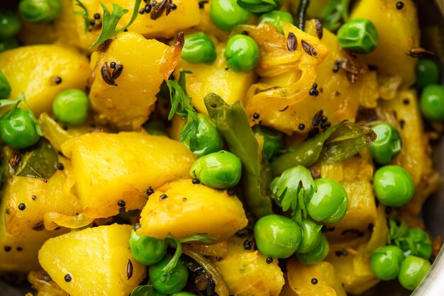 Aloo Mutter oder Matar aalu Dry Sabzi, indische Kartoffel und grüne Erbsen zusammen mit Gewürzen gebraten und mit Korianderblättern garniert. serviert mit Roti oder Chapati