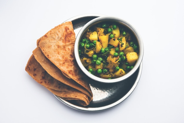 Aloo Mutter oder Matar aalu Dry Sabzi, indische Kartoffel und grüne Erbsen zusammen mit Gewürzen gebraten und mit Korianderblättern garniert. serviert mit Roti oder Chapati