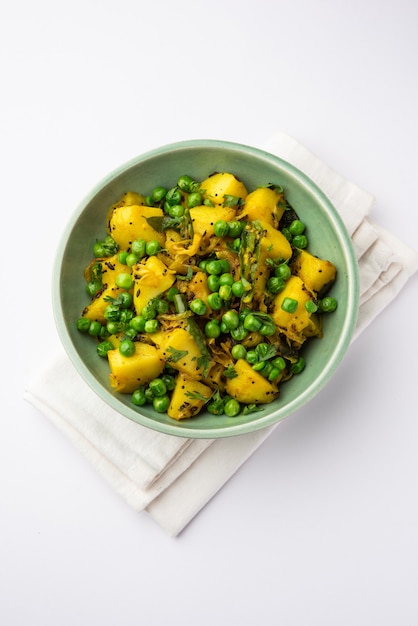 Aloo Mutter oder Matar aalu Dry Sabzi, indische Kartoffel und grüne Erbsen zusammen mit Gewürzen gebraten und mit Korianderblättern garniert. serviert mit Roti oder Chapati
