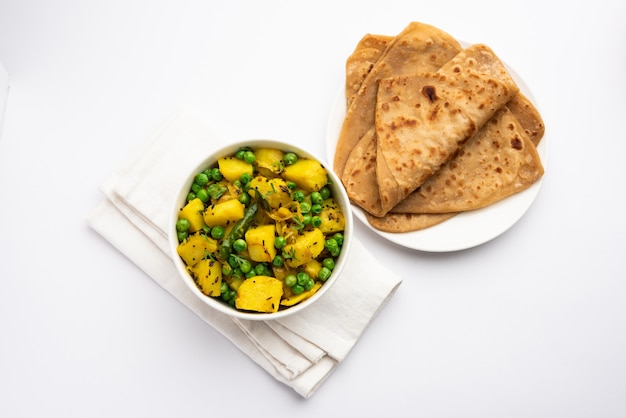 Aloo Mutter ou Matar aalu sabzi seco, batata indiana e ervilhas fritas com especiarias e guarnecidas com folhas de coentro. servido com roti ou chapati