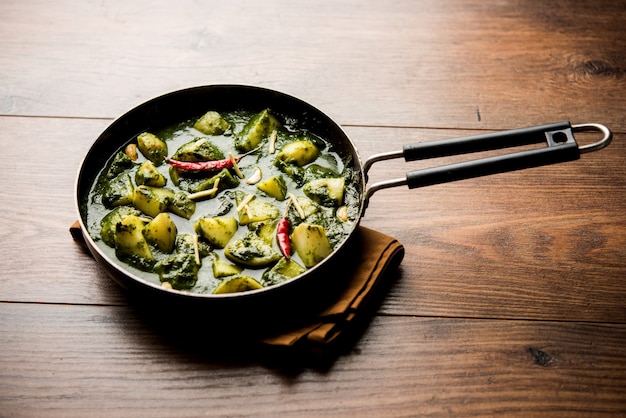 Aloo Palak sabzi ou curry de batata com espinafre servido em uma tigela. Receita saudável indiana popular. Foco seletivo