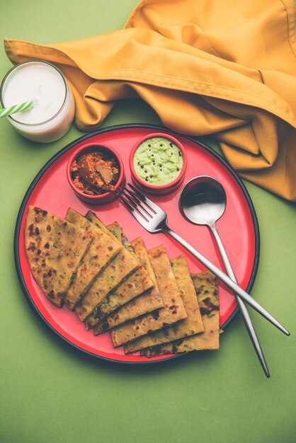 Aloo Paratha o pan plano relleno de papa india con mantequilla encima. Servido con Lassi dulce fresco, chutney y pepinillo. enfoque selectivo