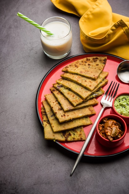 Aloo Paratha oder indische Kartoffel gefülltes Fladenbrot mit Butter obenauf. Serviert mit frischem süßem Lassi, Chutney und Gurke. selektiver Fokus