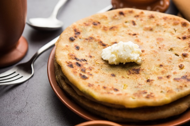 Aloo Paratha ou Batata Indiana recheada de pão achatado com manteiga por cima. Servido com Lassi doce fresco, chutney e picles. foco seletivo