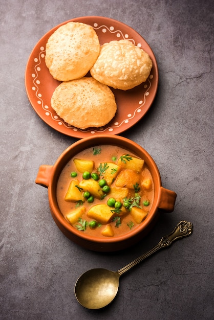 Aloo Puri o Papa al curry con Poori frito, popular menú indio para el desayuno o el almuerzo o la cena.