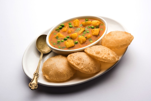 Aloo Puri o Papa al curry con Poori frito, popular menú indio para el desayuno o el almuerzo o la cena.