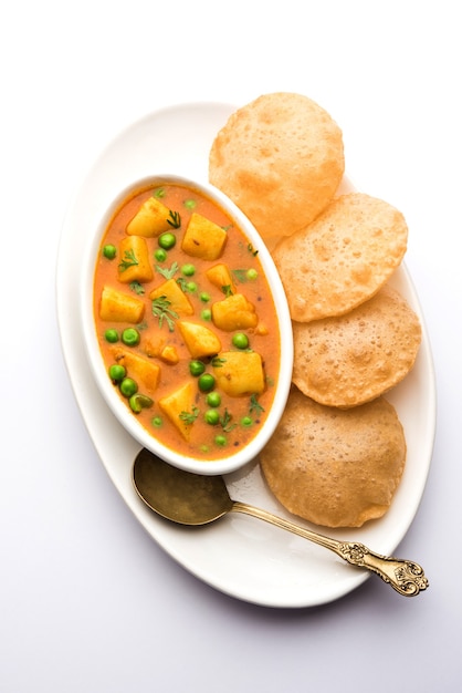 Aloo Puri o Papa al curry con Poori frito, popular menú indio para el desayuno o el almuerzo o la cena.