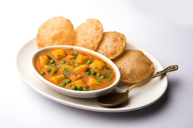 Aloo Puri o Papa al curry con Poori frito, popular menú indio para el desayuno o el almuerzo o la cena.