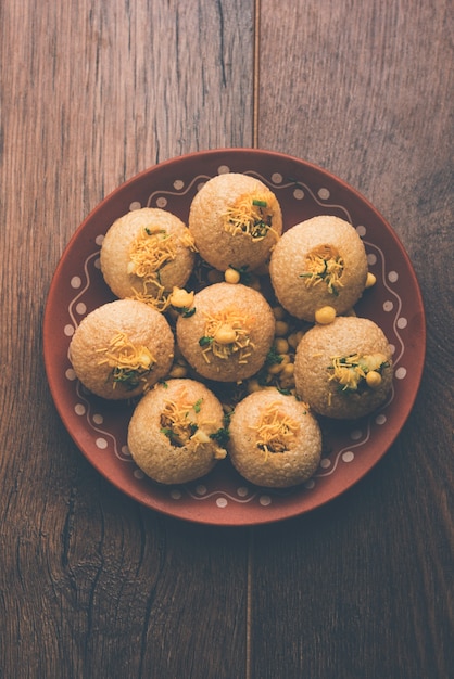 Aloo Sev Puri es un popular tema de charla en la carretera de la India, que se sirve en un plato blanco. Vista superior, enfoque selectivo