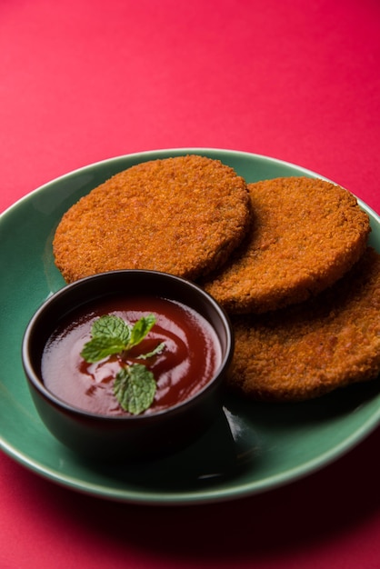 Aloo Tikki o Patties o Cutlet es un bocadillo o bocadillo popular de la India, servido con salsa de tomate o salsa picante Imli sobre un fondo de mal humor. Enfoque selectivo