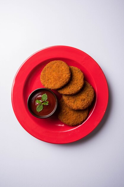 Aloo Tikki o Patties o Cutlet es un bocadillo o bocadillo popular de la India, servido con salsa de tomate o salsa picante Imli sobre un fondo de mal humor. Enfoque selectivo