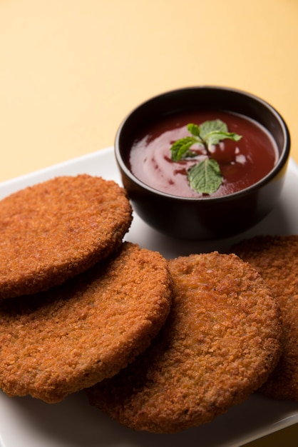 Aloo Tikki o Patties o Cutlet es un bocadillo o bocadillo popular de la India, servido con salsa de tomate o salsa picante Imli sobre un fondo de mal humor. Enfoque selectivo
