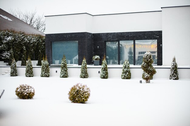 Alpendre de natal. pátio nevado com alpendre de natal, varanda, grinalda, árvore de natal, guirlanda, bolas de natal e lanternas.