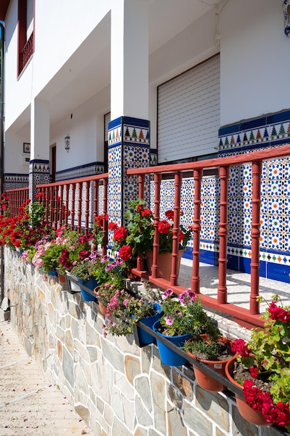 Alpendre decorado com azulejo azul e muitas flores coloridas