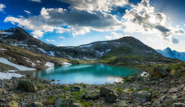 Alpensee mit letztem Schnee im Sommer