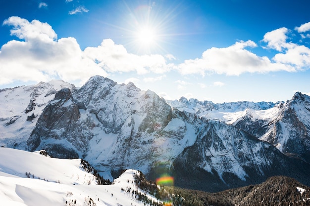 Alpes Dolomitas cobertos de neve em um dia ensolarado de inverno. Val di Fassa, Itália. Efeito de reflexo de lente