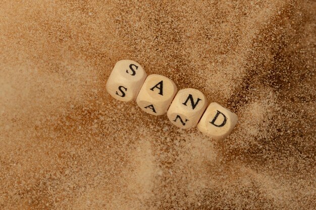 Alphabet Buchstaben Formulierung Sandperlen Spielzeug fliegen über Sand Explosion fliegen in der Luft Sand Wort Alphabet Buchstabe Show tropische Insel Strand Sand für Urlaub Urlaub Top View Action