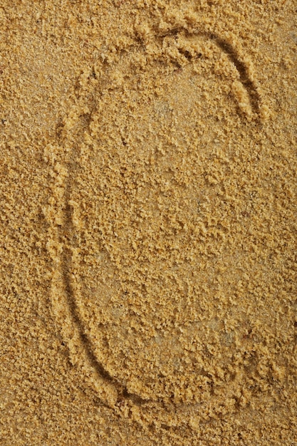 Alphabetbuchstabe geschrieben auf nassem Strandsand